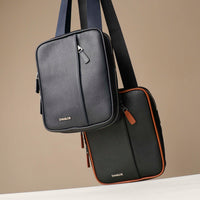Front view of a danilos navy blue and black crossbody dylan bag over a beige background