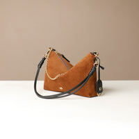 Brown Danilos suede handbag with gold chain detail on a beige background