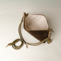 green sued eleather opened Danilos handbag with a strap on a light gray background
