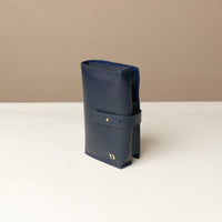 side view of a marine blue Danilos Pebble executive accessory holder linea on a beige background