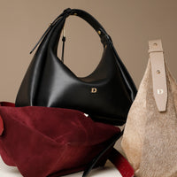 Black handbag, red clutch, and beige handbag with visible danilos logo on a neutral background