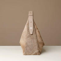Textured hair on leather Danilos handbag with leather strap on a neutral background