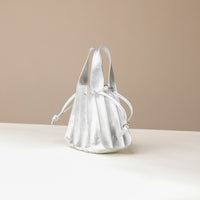Side view of a Danilos Handbag mini papillon junior in metallic silver color leather over a beige background