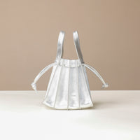 back view of a Danilos Handbag mini papillon junior in metallic silver color leather over a beige background
