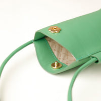 Green handbag with gold accents on a white background