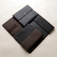 Set of black leather portfolios on a light beige background