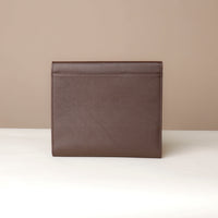 Brown leather clutch bag on a beige background