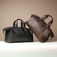front view of Two black and brown danilos hegarty travel bag over a beige background