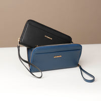 front view of a blue and black Danilos wallet Carlota with a visible handle drop in a beige background