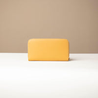 back view of a Yellow Danilos wallet Carlota in a beige background